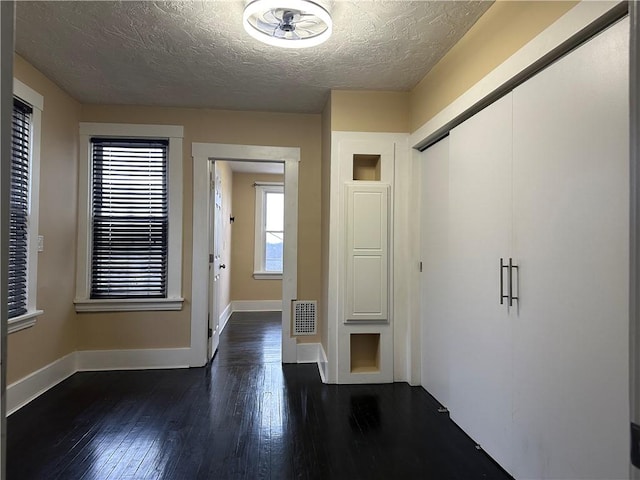 entrance foyer featuring a textured ceiling and dark hardwood / wood-style floors