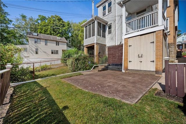 view of yard featuring a balcony, a patio area, and a sunroom