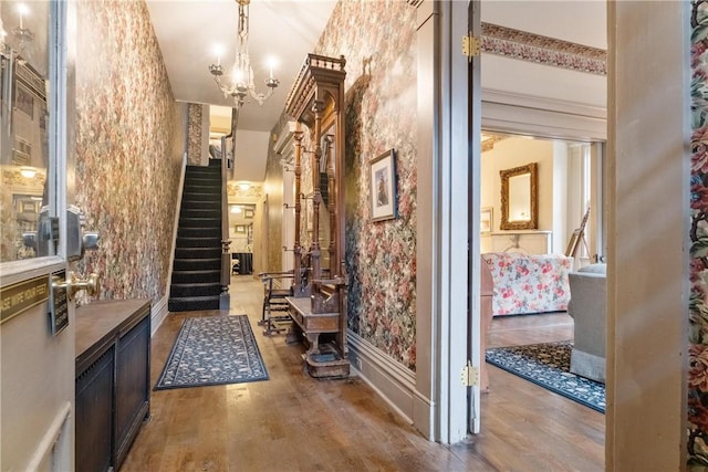 hall featuring hardwood / wood-style floors and an inviting chandelier