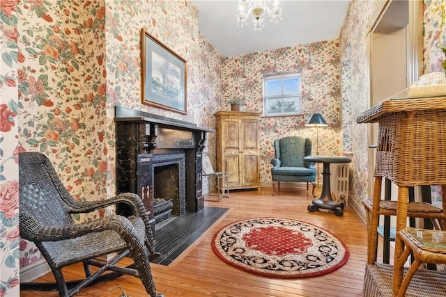 sitting room with an inviting chandelier and light hardwood / wood-style flooring