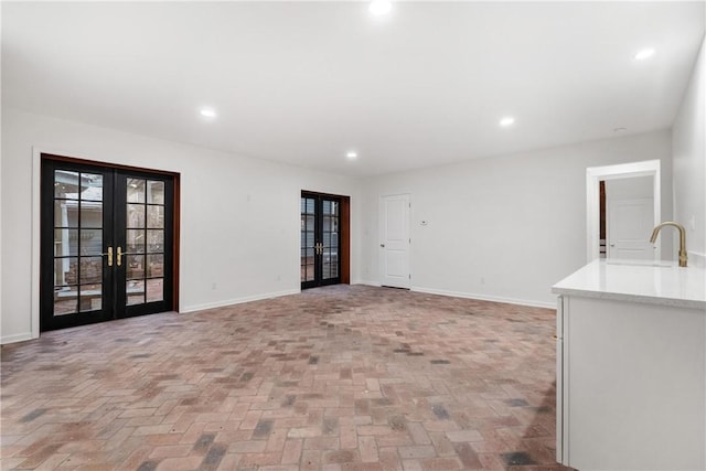 unfurnished living room with sink and french doors