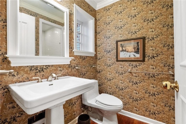 bathroom featuring hardwood / wood-style flooring, toilet, and crown molding