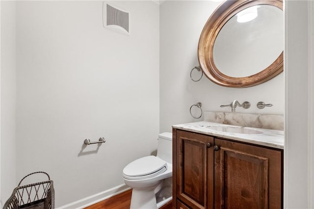 bathroom with hardwood / wood-style floors, vanity, and toilet