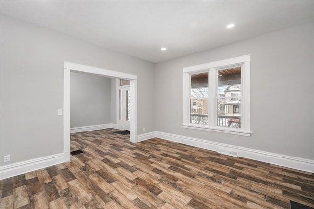 unfurnished room with dark hardwood / wood-style flooring