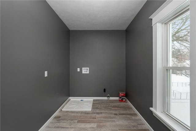 clothes washing area with washer hookup, a textured ceiling, and wood-type flooring