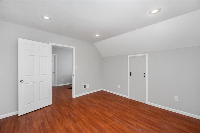 bonus room with vaulted ceiling and dark wood-type flooring