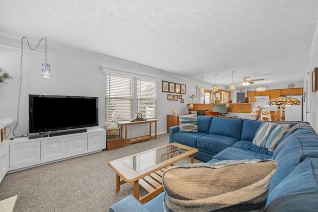 carpeted living room featuring a textured ceiling, ceiling fan, and crown molding