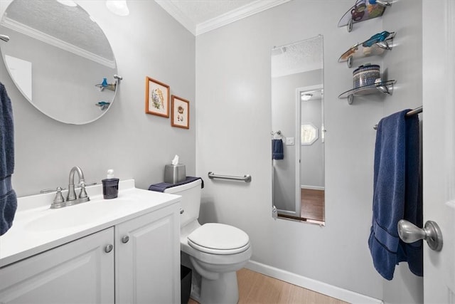 bathroom featuring toilet, vanity, a textured ceiling, and ornamental molding