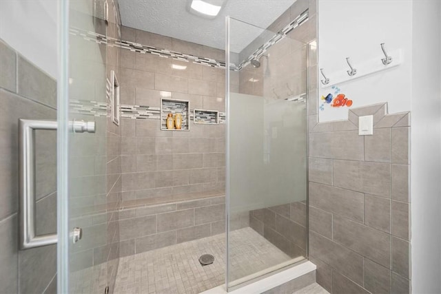 bathroom with a textured ceiling and walk in shower