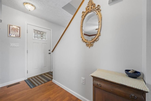 foyer featuring hardwood / wood-style flooring and a textured ceiling