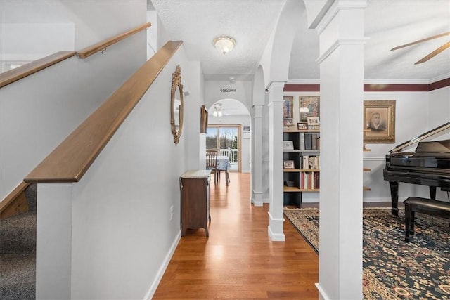 foyer featuring decorative columns, ceiling fan, a textured ceiling, and light wood-type flooring