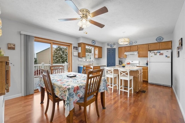 dining room with a textured ceiling, light hardwood / wood-style flooring, ceiling fan, and sink