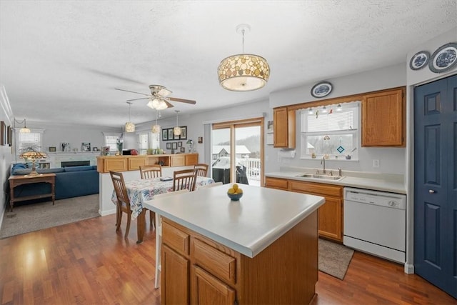 kitchen with ceiling fan, dishwasher, a center island, sink, and decorative light fixtures