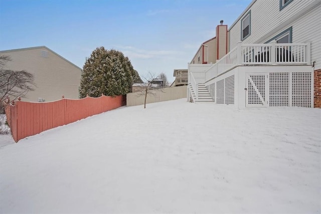 yard covered in snow featuring a deck