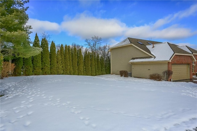 view of snow covered exterior featuring a garage