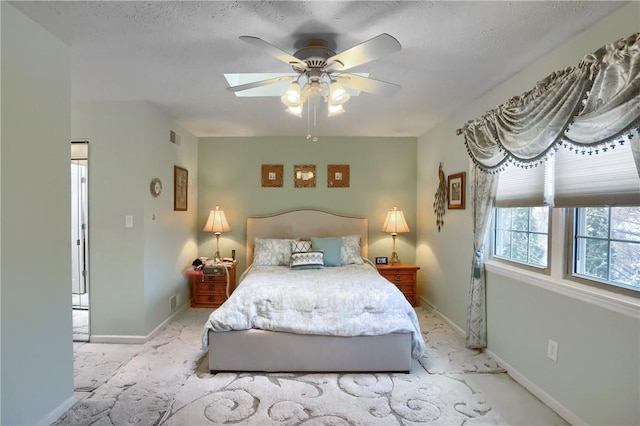 bedroom featuring ceiling fan, light colored carpet, and a textured ceiling