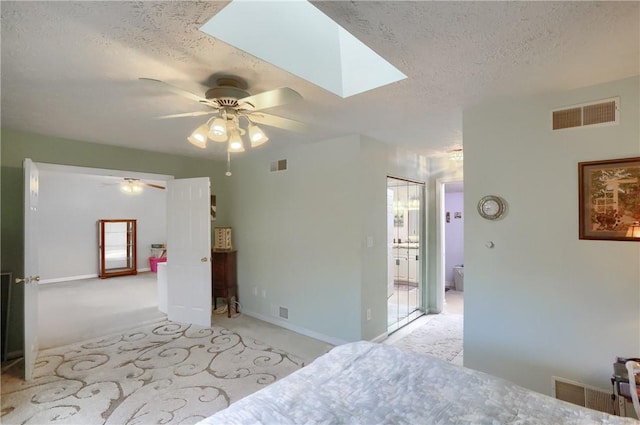 bedroom with a textured ceiling, ceiling fan, and light colored carpet