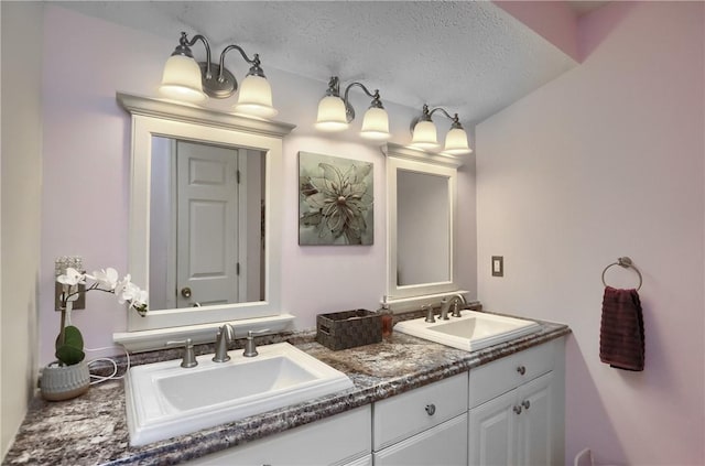 bathroom featuring a textured ceiling and vanity