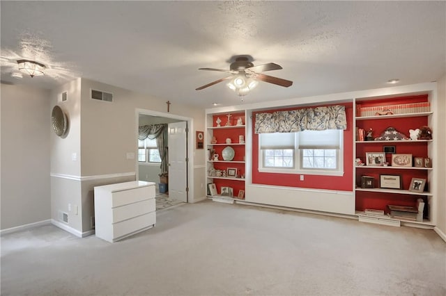 unfurnished living room featuring a textured ceiling, carpet floors, and ceiling fan