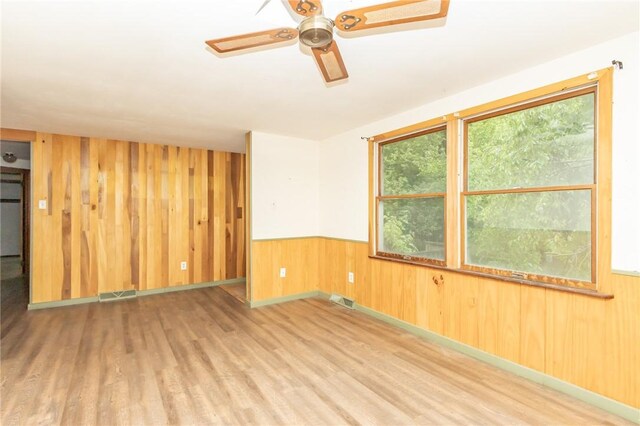 119 Deer Rd, Loyalhanna, PA 15681 - unfurnished room featuring wood walls, wood finished floors, a ceiling fan, and a wainscoted wall