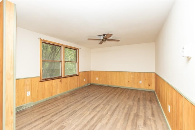 119 Deer Rd, Loyalhanna, PA 15681 - empty room featuring wainscoting, wood walls, light wood-style flooring, and ceiling fan