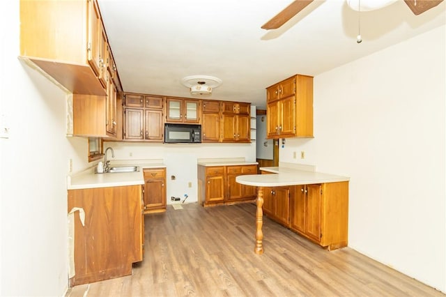 119 Deer Rd, Loyalhanna, PA 15681 - kitchen with black microwave, brown cabinets, wood finished floors, a ceiling fan, and a sink