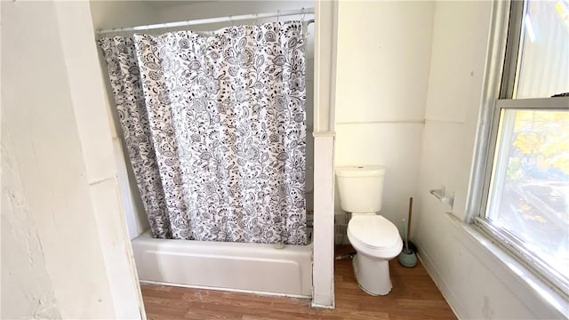 bathroom with hardwood / wood-style flooring, toilet, and shower / bath combo with shower curtain