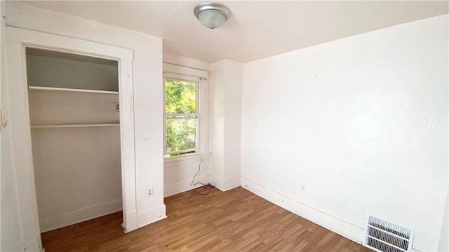 unfurnished bedroom featuring a closet and hardwood / wood-style floors