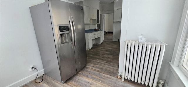 kitchen featuring hardwood / wood-style flooring, stainless steel fridge, and radiator