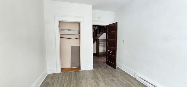 empty room featuring a baseboard radiator and light hardwood / wood-style flooring