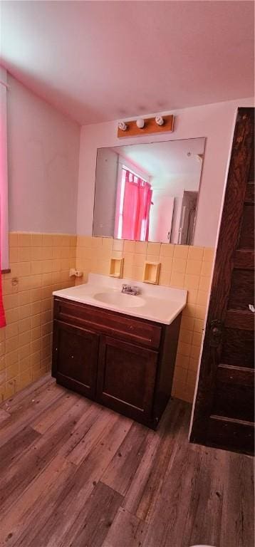 bathroom featuring hardwood / wood-style flooring, vanity, and tile walls