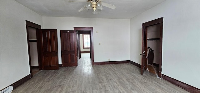 unfurnished bedroom featuring light hardwood / wood-style floors, baseboard heating, and ceiling fan