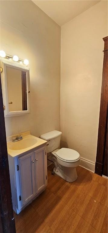 bathroom with hardwood / wood-style floors, vanity, and toilet