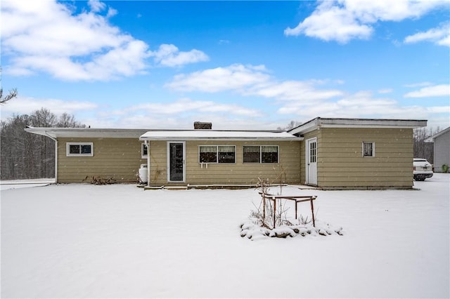 view of snow covered rear of property