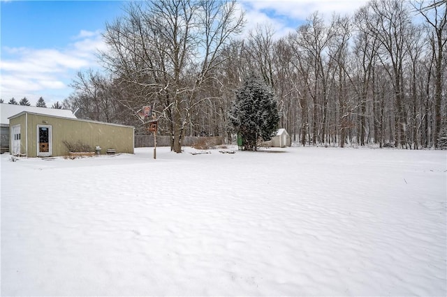 yard layered in snow featuring an outbuilding