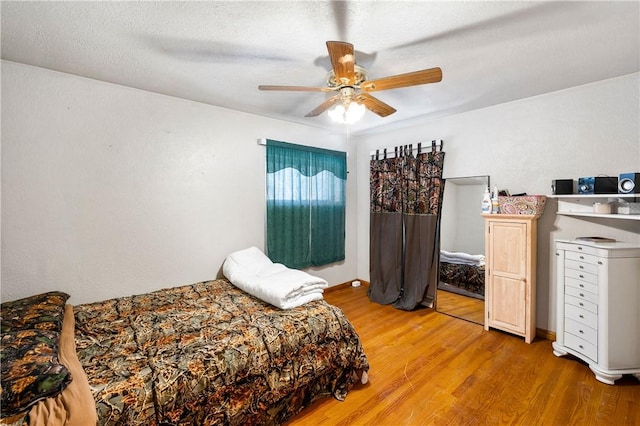 bedroom featuring ceiling fan, a textured ceiling, and light hardwood / wood-style flooring