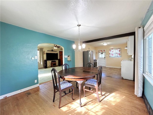 dining space featuring washer / clothes dryer, plenty of natural light, light hardwood / wood-style floors, and a notable chandelier