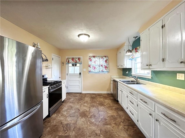 kitchen featuring hanging light fixtures, white cabinetry, sink, and stainless steel appliances