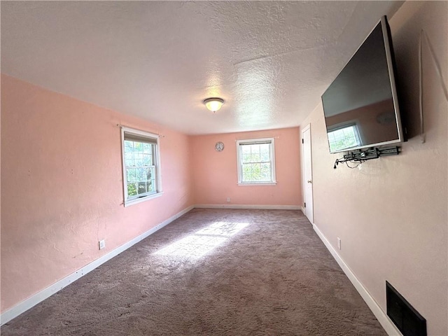 carpeted spare room with a textured ceiling