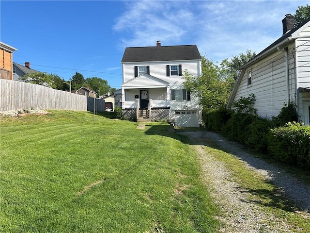 rear view of house with a lawn and a porch