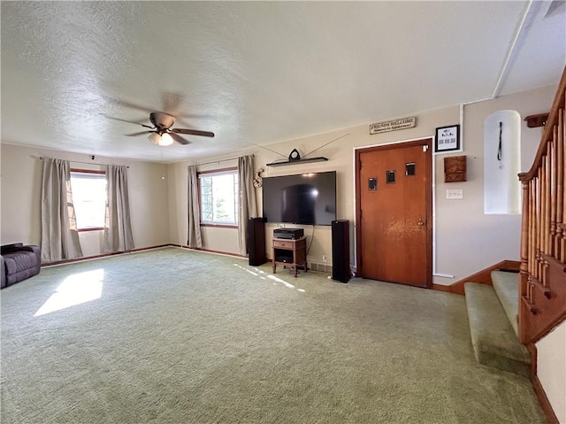 unfurnished living room with a textured ceiling, carpet floors, and ceiling fan