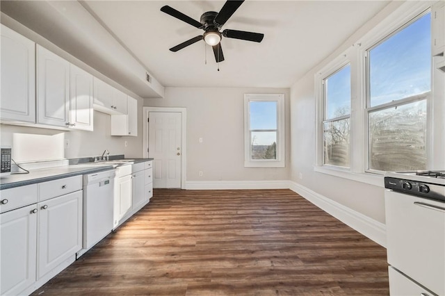 kitchen with white dishwasher, white cabinets, stove, and dark wood-type flooring