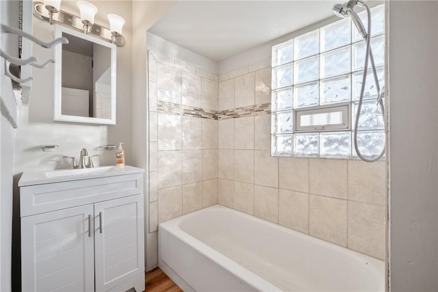 bathroom featuring vanity, hardwood / wood-style flooring, and tiled shower / bath