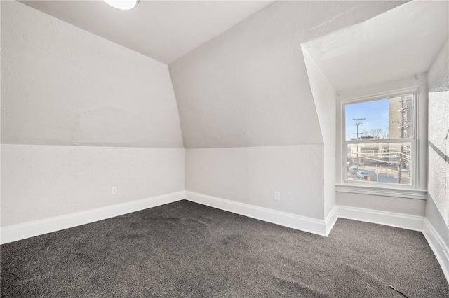 bonus room with carpet flooring and vaulted ceiling