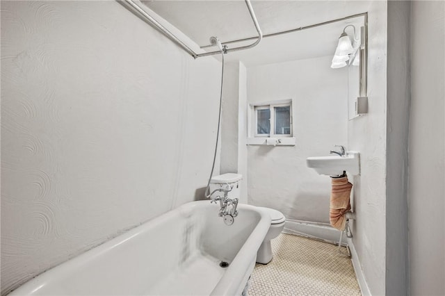 bathroom featuring toilet, tile patterned flooring, and a washtub