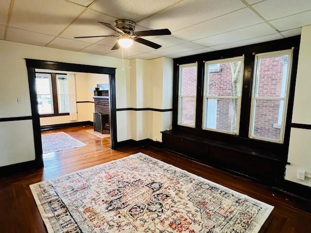 entrance foyer featuring dark wood-type flooring, a drop ceiling, a healthy amount of sunlight, and ceiling fan