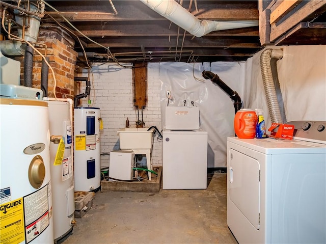 basement featuring water heater, washer and clothes dryer, brick wall, and gas water heater