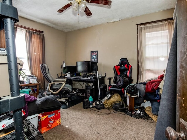 carpeted home office featuring plenty of natural light and ceiling fan