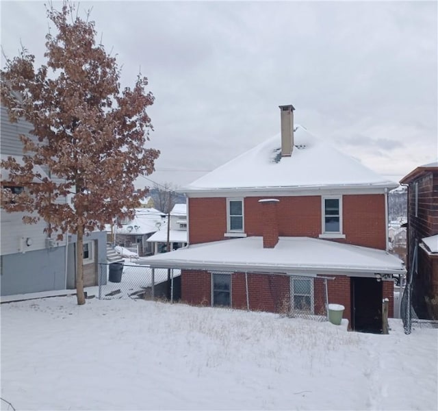 view of snow covered back of property