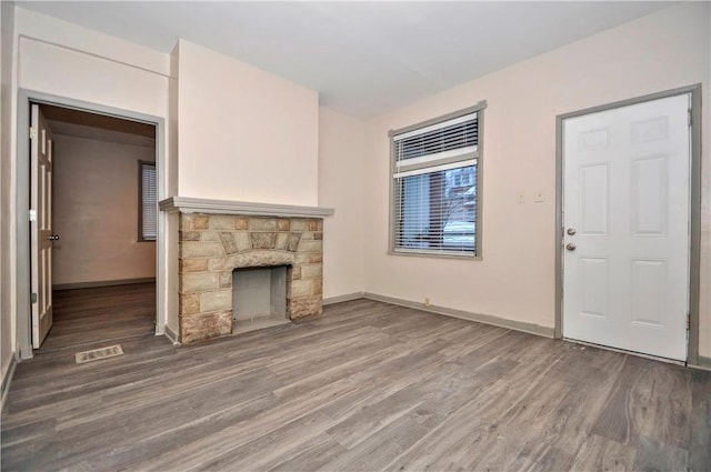 unfurnished living room featuring a fireplace and dark hardwood / wood-style flooring